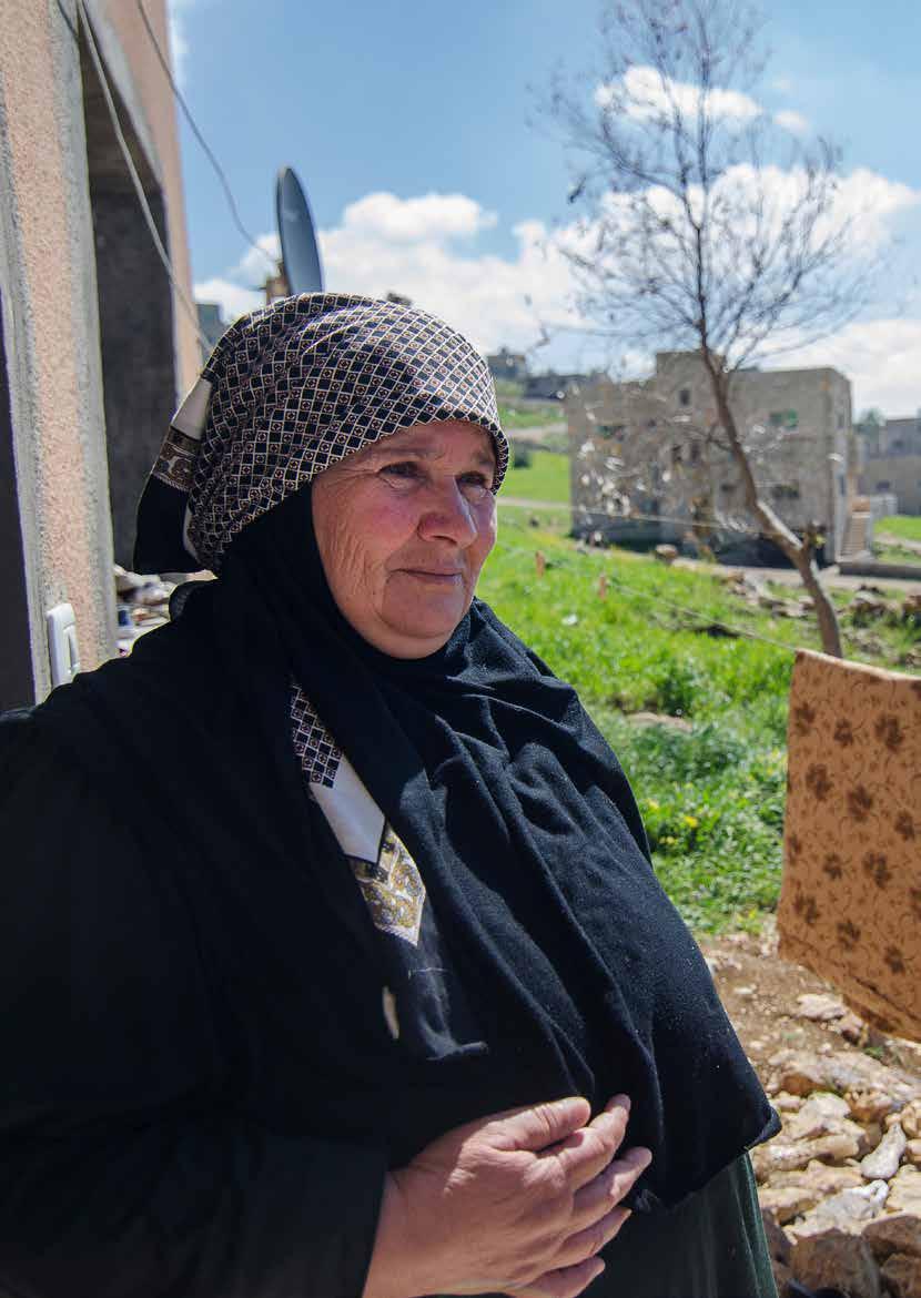 Page 7 Raoufa, 62, stands outside of her new rent-free home