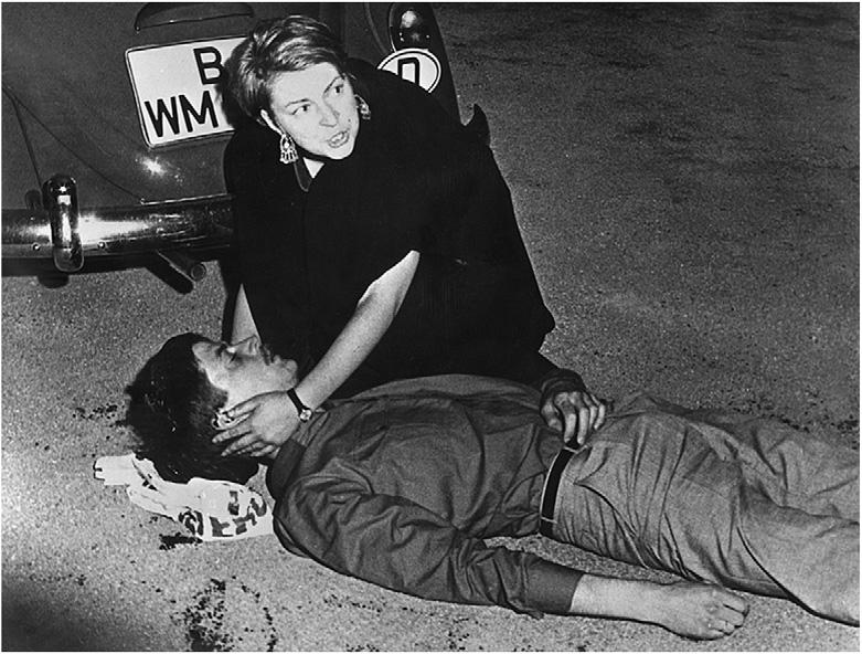 German student Benno Ohnesorg, dead in the arms of pedestrian Friederike Hausmann, after being shot by detective Kurras on June 2, 1967.