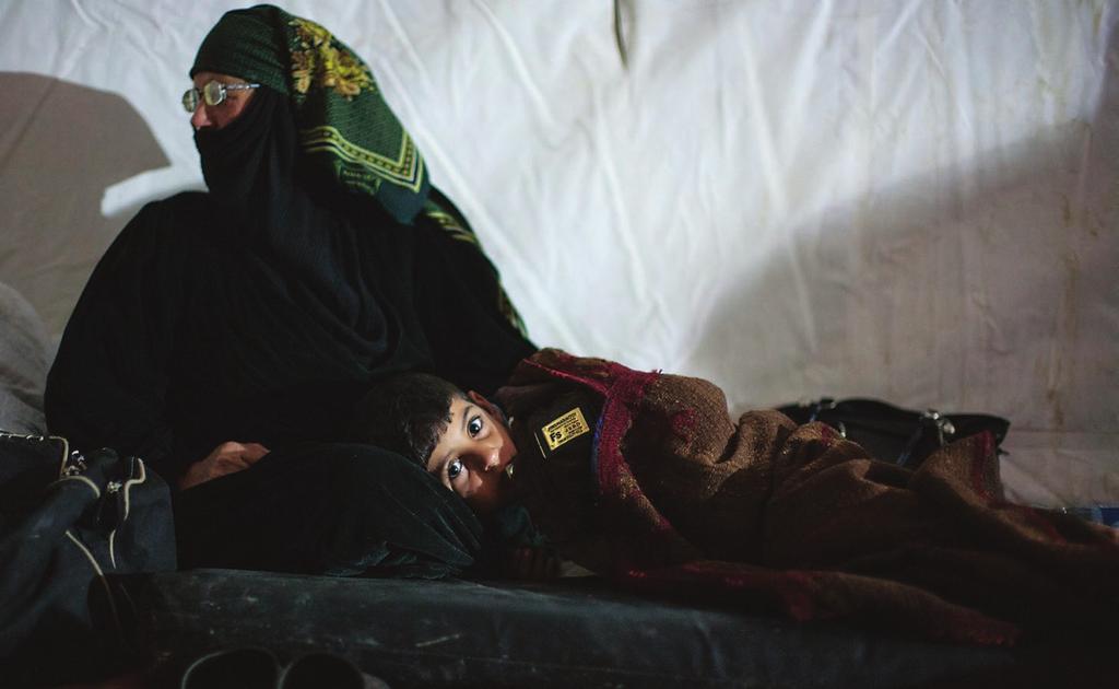 A Syrian woman comforts her grandson in the arrivals area at Za atri refugee camp.