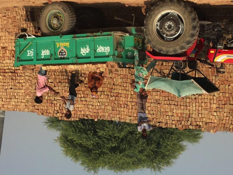 Adults and children loading a vehicle at a brick kiln in Bharatpur.
