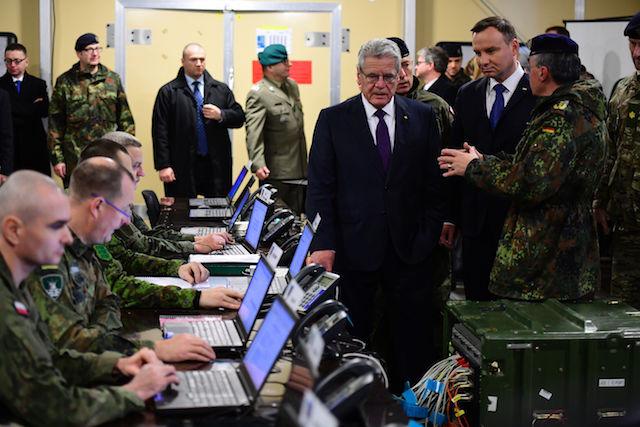 German President Joachim Gauck (C) and his Polish counterpart Andrzej Duda (Center R) listen to explanations inside the "Main Command Post" operated by both countries' soldiers during a visit of the