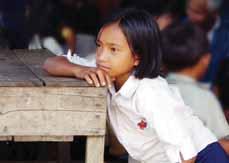 case for the youngster here. Others, such as this young girl from Bak Ang Rut, photographed in 2004, are more fortunate and are able to fit schooling around their other responsibilities.