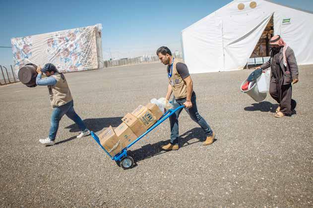 2014 Syria Regional Response Plan - Mid-Year Update ACTED staff help a refugee carry the food packages and other essential items that his family will need as they begin a new life at Azraq camp,