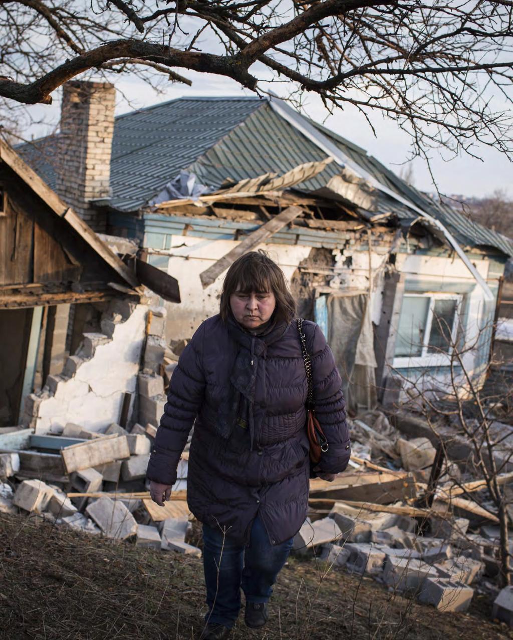 Liudila Khomenko walks away from her home near Mariupol, Ukraine,
