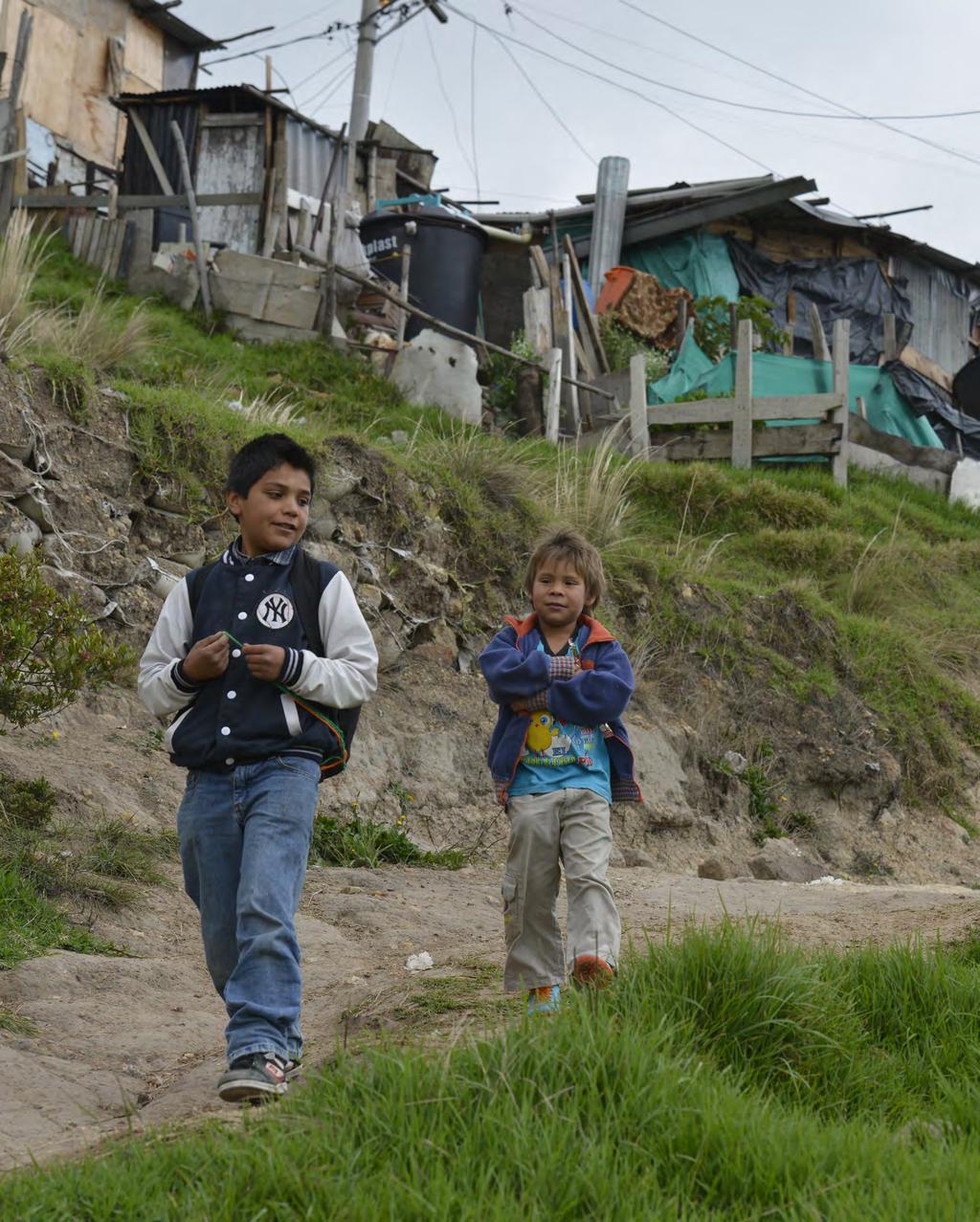 Internally displaced children walk home from the UNHCR supported educational learning centre in the outskirts of Soacha, Colombia.