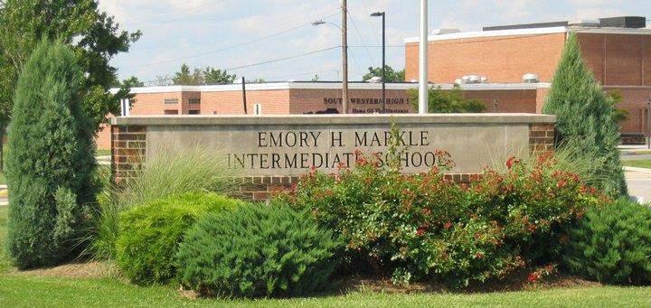 4:00 AM Students arrive at Emory H. Markle Intermediate School The entrance sign to Emory H. Markle Intermediate School. The high school is in the background.