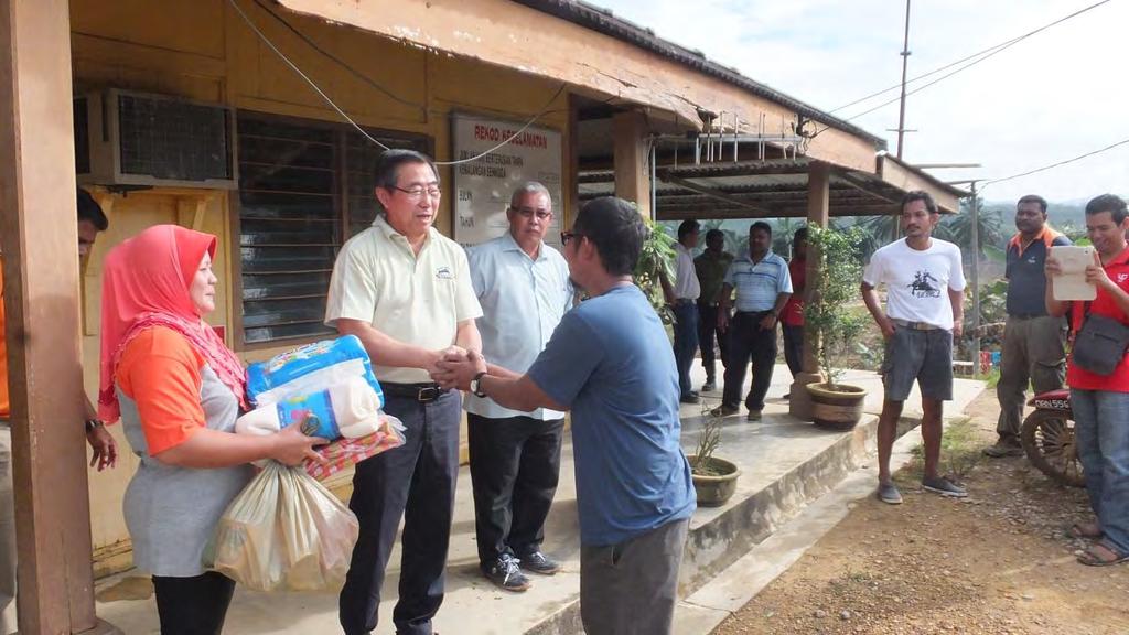 Tan Sri Lee meeting and handing out basic necessities to