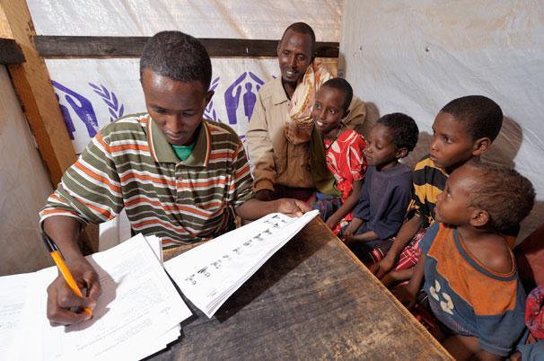 A newly arrived Somali refugee family is interviewed by a worker for the ACT Alliance during the registration process for new refugees in the Dadaab refugee camp in
