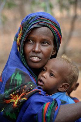 Habiba Nuno, 25, with one of her children as she pauses to rest while trekking across eastern Kenya near the Somali border.
