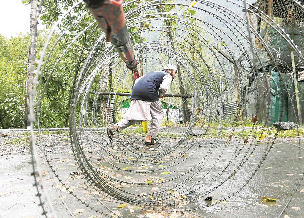 INTERNATIONAL 16 World News Roundup Africa A Kashmiri man ducks to cross an iron barricade with coils of razor wire near a military base at Braripora, near the de facto border dividing Kashmir