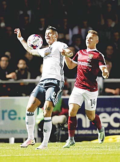 Northampton Town s Sam Hoskins (right), and Manchester United s Marcos Rojo battle for the ball during the English League Cup third round soccer match at Sixfields Stadium, Northampton, England, on