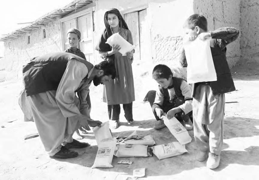114 HUMANITARIAN AIRDROPS A group of Afghan children collecting packets of food aid after a U.S. aircraft completed a night time air drop over a refugee camp in Kumkishlyak in Northern Afghanistan, 25 October 2001.