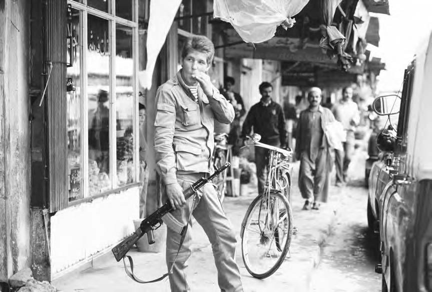 236 SOVIET WAR IN AFGHANISTAN A young Soviet soldier carries an AK-47 rifle on a busy shopping street in Kabul.