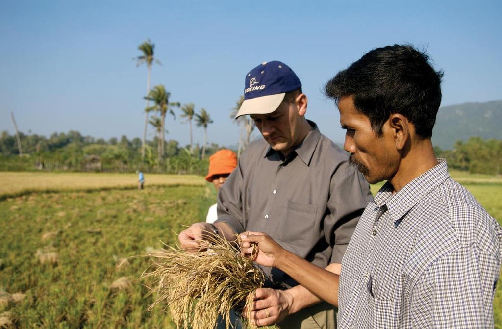 Bob Seipel inspects a stalk of rice with a farmer in a rice paddy outside of the city of Banda Aceh.