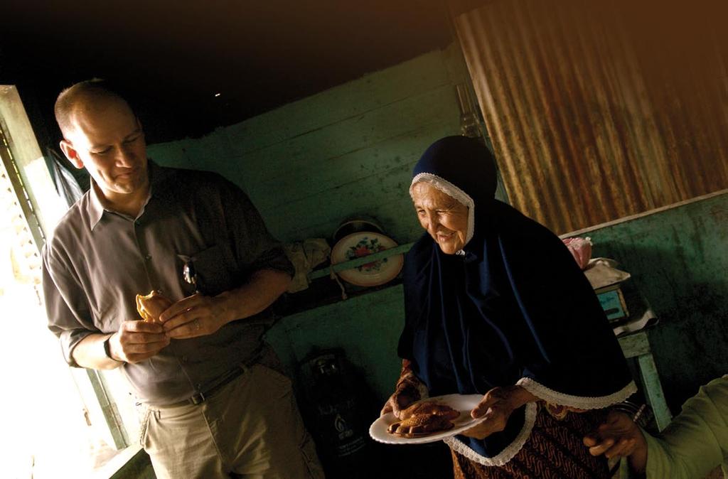 Aceh business owner Ms. Sadiah as she offers a plateful of cakes to visitors including Bob Seipel.