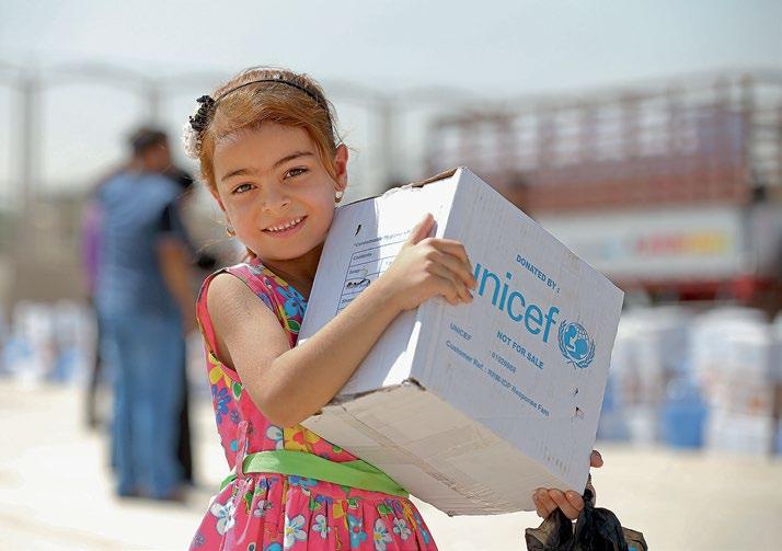 UNICEF/Khuzaie A displaced child picks up an emergency supply kit at a distribution centre in Iraq.