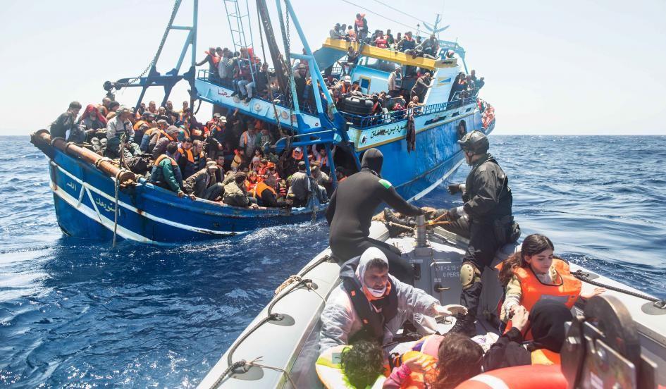 Refugees and migrants, packed aboard a fishing boat in the