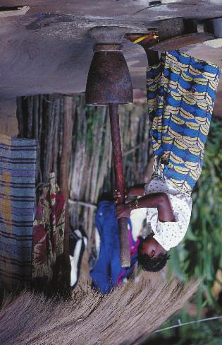 A Congolese refugee grinding grain in