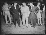 Soldier inspecting a couple of "zoot suits" at the Uline
