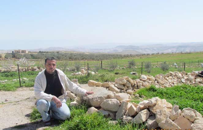 Resident of Jubbet adh Dhib (Bethlehem), next to stones from his demolished home. Photo by OCHA.