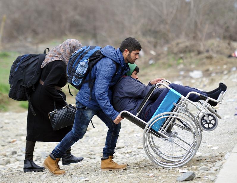 Unicef/Georgiev DIFFICULT JOURNEYS: THE FORMER YUGOSLAV REPUBLIC OF MACEDONIA PHOTO SHEET 6 A man helps a boy in a wheelchair get to the train station outside Vinojug transit