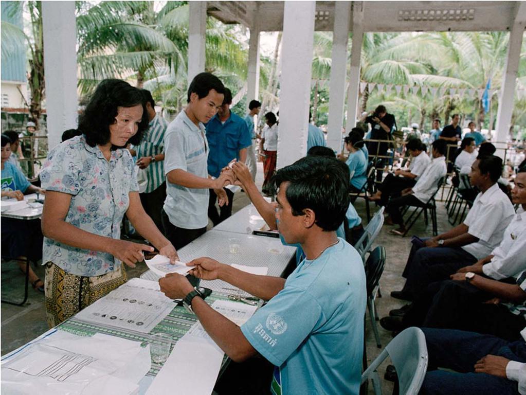 A woman receiving her ballot from an UNTAC electoral staff member.